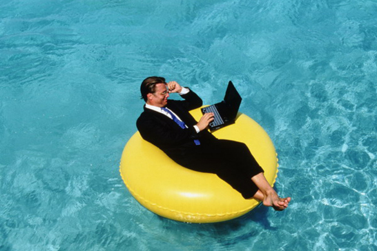 Businessman using laptop on float - Aruba