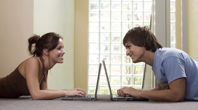 Teenage girl and a young man using laptops